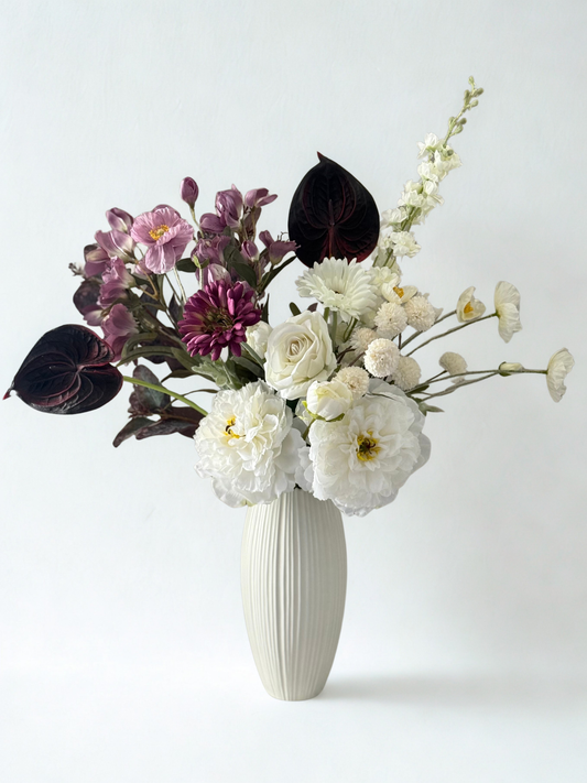 Floral arrangement in a white vase on a white background