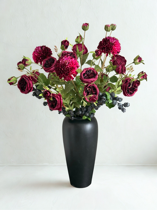Black vase with burgundy flowers on a white background