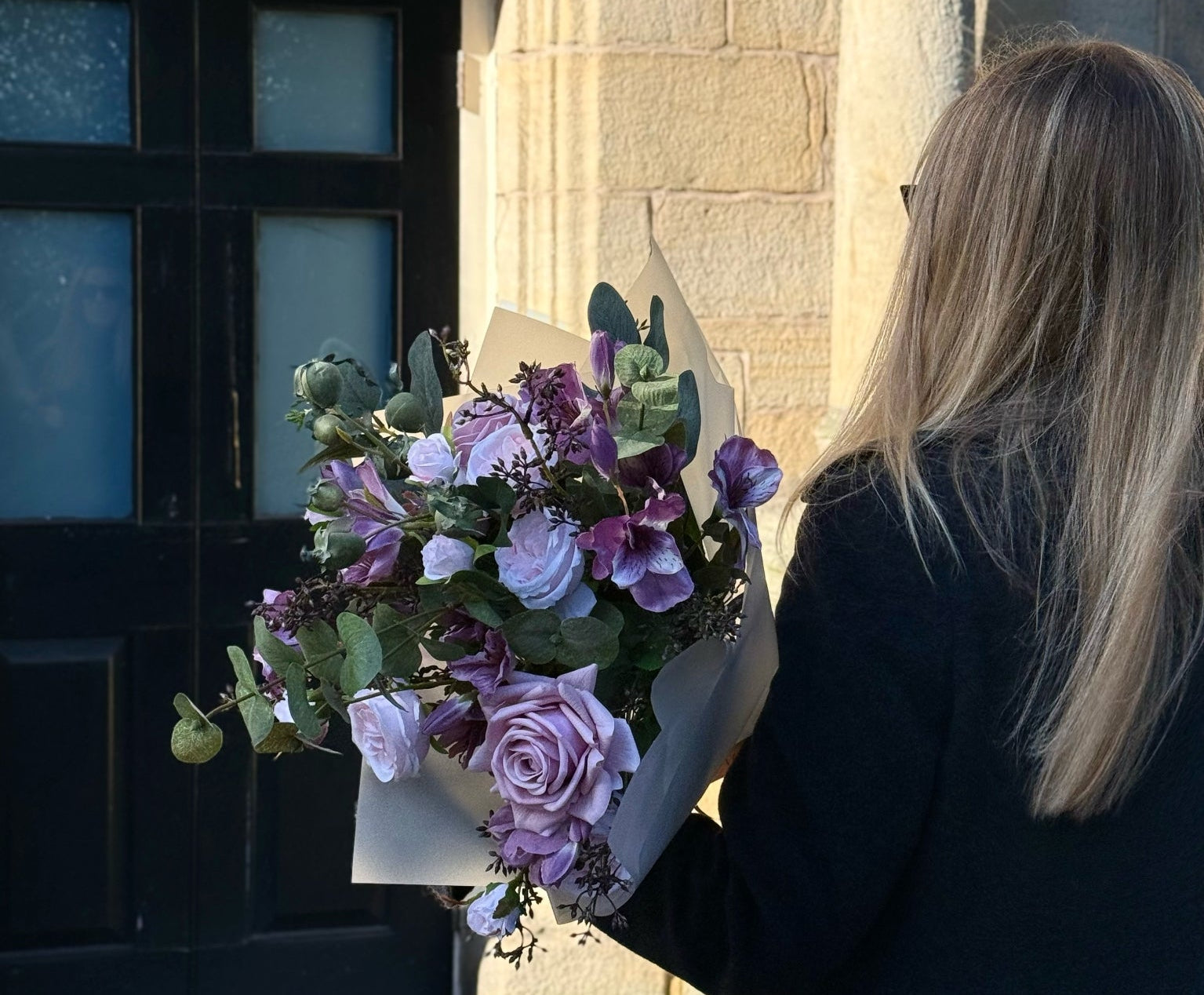 Best & Bloom Realistic Artificial Bouquet with Woman in front of a building