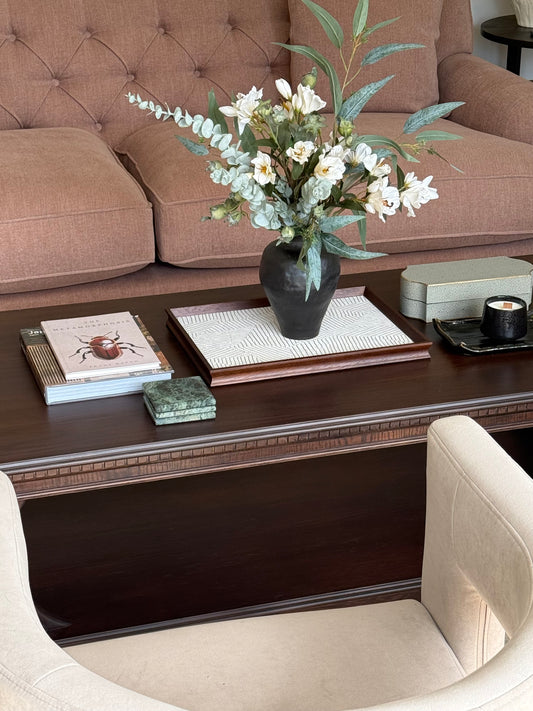 Living room with a brown sofa, wooden coffee table, and decorative items.