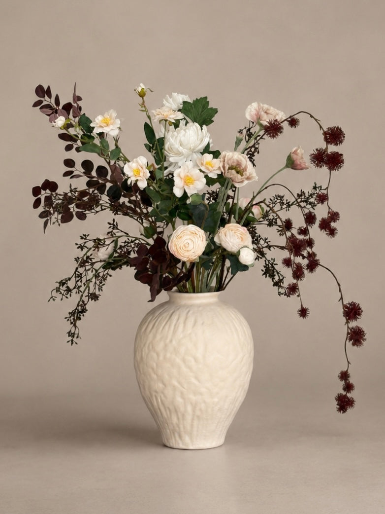 White vase with a bouquet of flowers on a beige background best artificial bouquets