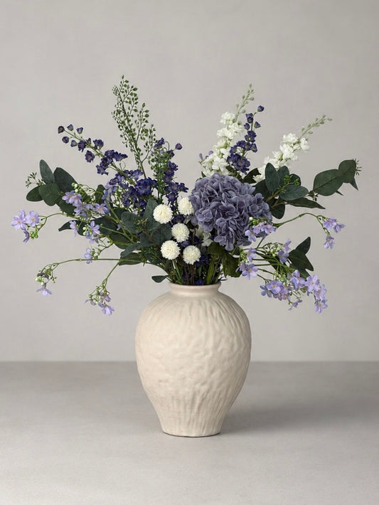 White vase with a bouquet of flowers on a gray background