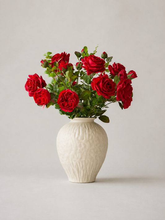 White textured ceramic vase with red roses on a light gray background
